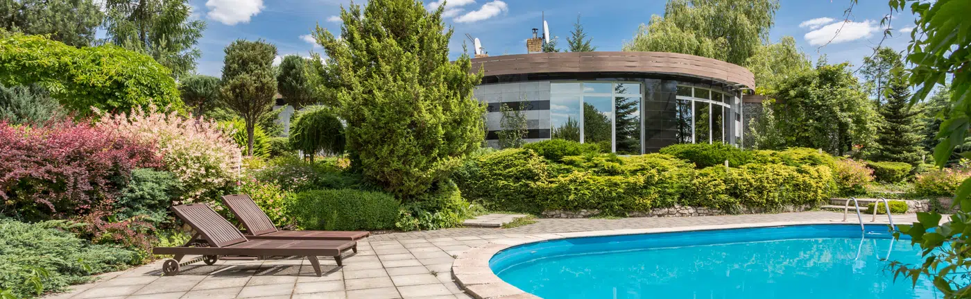 Contemporary architectural residence with curved stone facade and swimming pool