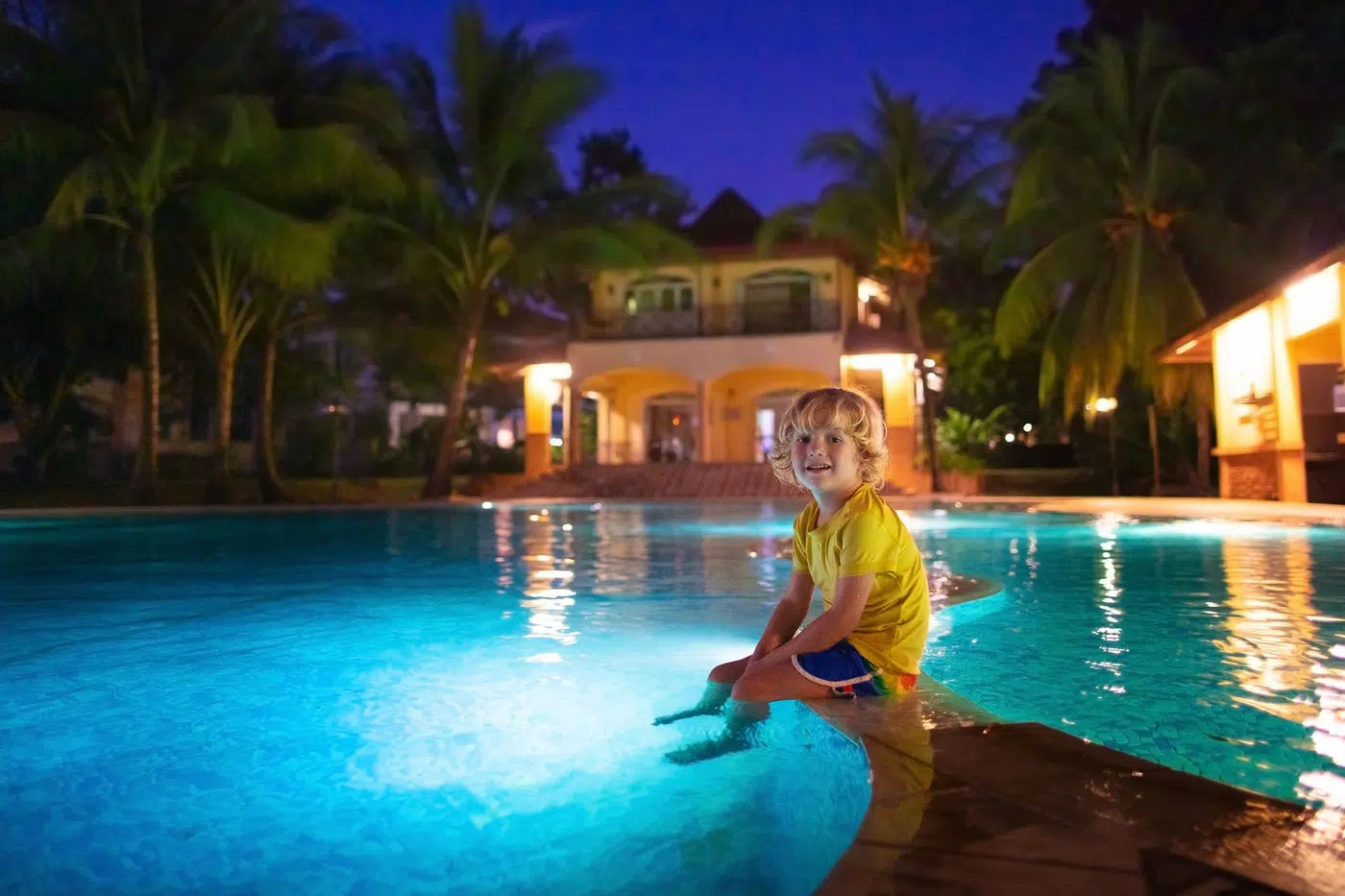 Illuminated swimming pool and terrace at dusk