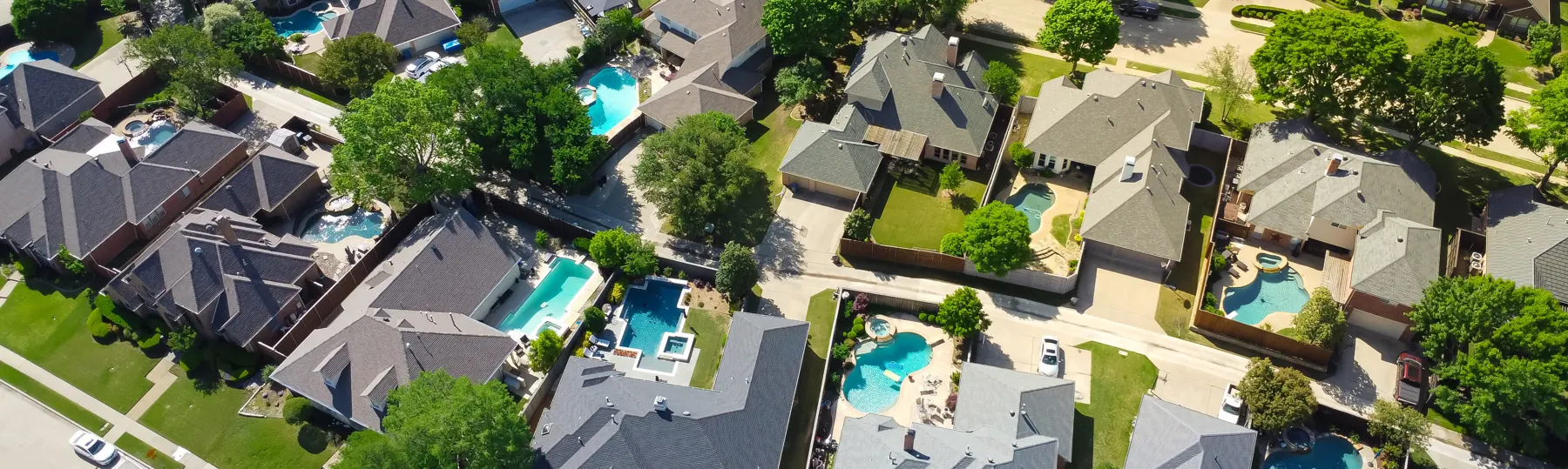 Aerial view of modern residential properties with private backyard swimming pools