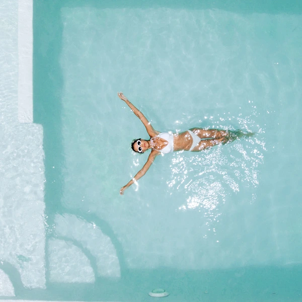 Woman floating in crystal-clear nanobubble pool water